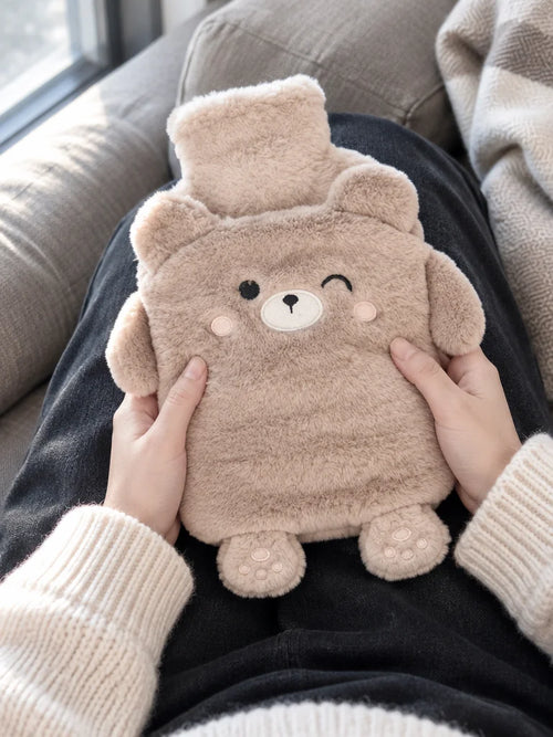 A close portrait photograph cropped at the waist, showing the beige bear-shaped Ondine hot-water bot